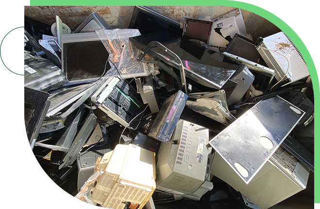 A pile of electronics and computers in the trash.